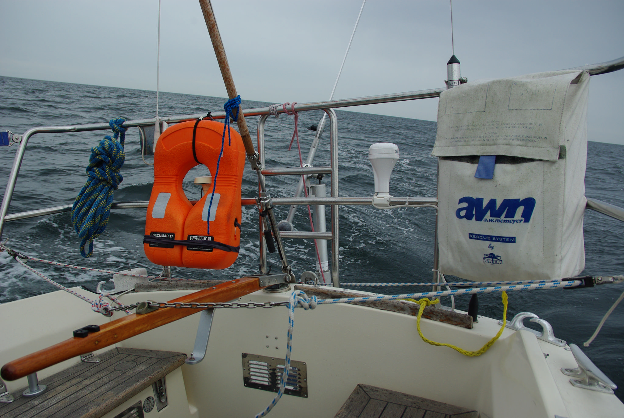 Windsteueranlage in Betrieb, die Steuerkette auf der Pinne wird von der WSA am Heck so gesteuert, dass die weiß lackierte Sperrholzwindfahne genau im Wind steht. Der Winkel wird am Halterohr eingestellt, so dass alle Kurse zum Wind gesteuert werden können.